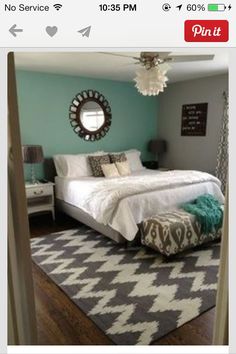 a bedroom with a bed, rug and mirror