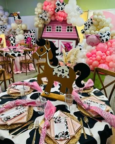 a table set up with pink, black and white balloons in the shape of a horse