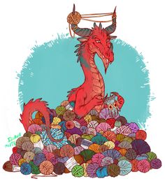 a red dragon sitting on top of a pile of balls of yarn