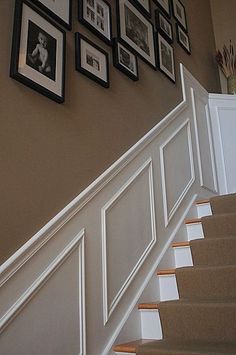 a staircase with pictures on the wall and framed photos on the wall next to it