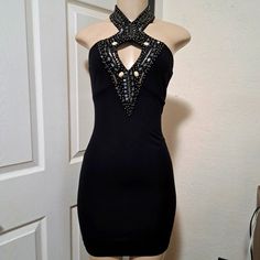 a black dress on display in front of a white door with the back cut out