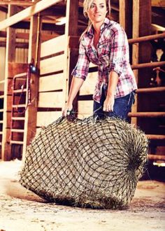 a woman is holding a large piece of hay