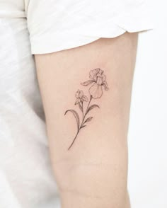 a small flower tattoo on the left thigh