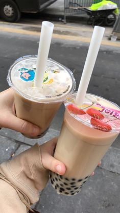 two people holding up drinks in their hands