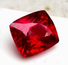 a red diamond sitting on top of a white surface