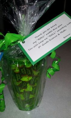 a vase filled with green candies next to a sign that says thank you all