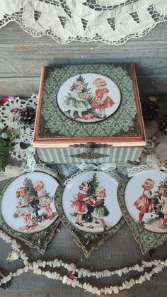 four christmas plates in a box on top of a table with lace doily around them