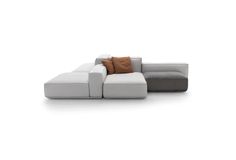 a white couch with brown pillows on the back and armrests, sitting against a white background