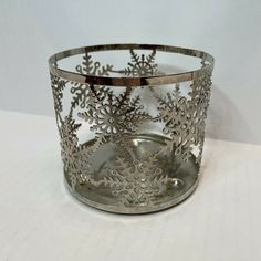 a metal candle holder with snowflakes on it