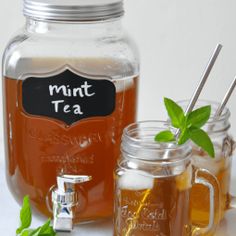 two mason jars filled with tea and mint leaves