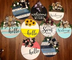 six door hangers decorated with sunflowers and welcome home signs on a wooden floor