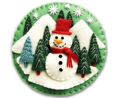 a christmas ornament with a snowman and trees on it