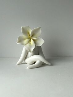 a white ceramic flower sitting on top of a table