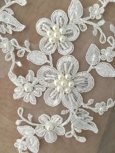 an embroidered lace with flowers and pearls on the bottom is shown in this close up photo