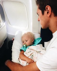 a man holding a baby on an airplane