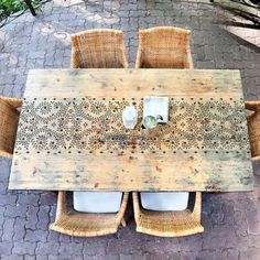 an outdoor table and chairs made out of pallet wood with two white vases on top