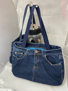 a blue jean purse with a bottle in it