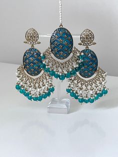 Please visit our website www.sakavano Jewellery.com for all offers.  A beautiful handpainted Kundan pair of earrings and tikka set that come with pearls.   These earrings are super lightweight and are a true statement piece.   Please follow out Instagram page @sakavano_jewellery for all our latest offers.  Please note we do not offer any refunds or exchanges due to hygiene reasons Turquoise Kundan Earrings For Wedding, Traditional Turquoise Earrings For Wedding, Turquoise Earrings For Wedding And Festivals, Turquoise Kundan Earrings For Festivals, Turquoise Kundan Chandbali Earrings, Turquoise Meenakari Earrings For Wedding, Traditional Turquoise Danglers For Wedding, Traditional Turquoise Danglers For Gift, Traditional Turquoise Earrings For Diwali