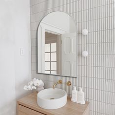 a bathroom with a sink, mirror and soap dispenser on the counter