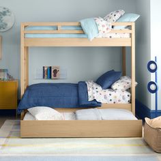 a bunk bed with blue sheets and pillows in a child's playroom or bedroom