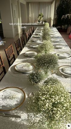 a long table with plates and flowers on it