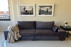 a living room with two pictures on the wall and a couch in front of it