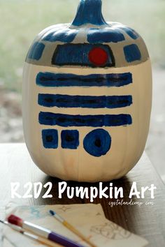 a painted pumpkin sitting on top of a wooden table