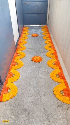 orange and yellow flowers are laid out on the concrete