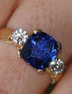 a woman's hand with a blue and white ring on top of her finger