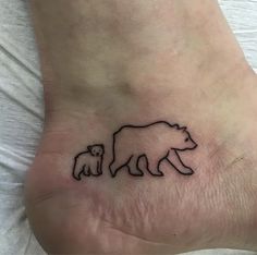 a small bear and cub tattoo on the foot