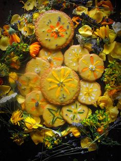 there are some cookies that have been decorated with yellow flowers and daisies on the table