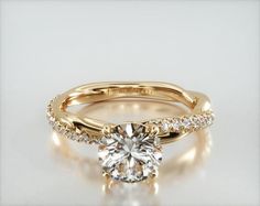 a yellow gold engagement ring with a round cut diamond in the center and side stones on each band