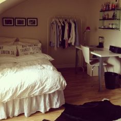 a bedroom with a bed, desk and shelves on the wall next to each other