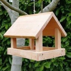 a wooden bird house hanging from a tree