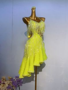 a mannequin wearing a yellow dress with sequins on it