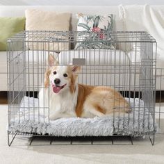 a dog is sitting in a cage on the floor next to a couch and pillows