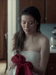 a woman in a white dress holding a red towel