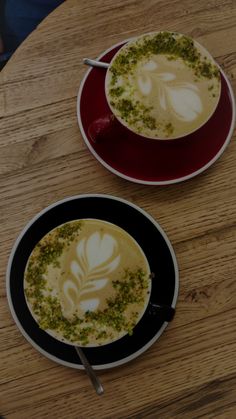 two cups of coffee on top of a wooden table