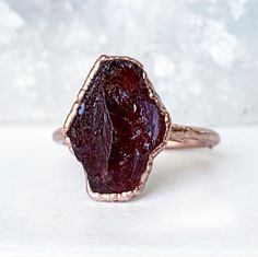 A gorgeous raw garnet gemstone is electroformed with pure copper, creating a unique and organic looking setting for this January birthstone. ***This listing is for one garnet ring.Each ring is made by hand and electroformed for 12 hours, allowing a unique copper design to develop and encase the stone. Rings are then buffed, polished and sealed with a protective layer to maximize luster, keep the bright and clean rose gold tone, and prevent potential tarnishing and skin discoloration that can occ Raw Garnet Ring, Twilight Dr, Raw Stone Engagement Rings, Garnet Stone Ring, Rough Gemstone Ring, Raw Garnet, Healing Crystal Ring, January Birthstone Rings, Raw Crystal Ring