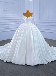 a white wedding dress on display in a room