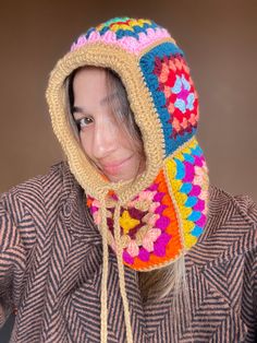 a woman wearing a crocheted hat and scarf with a hood on her head