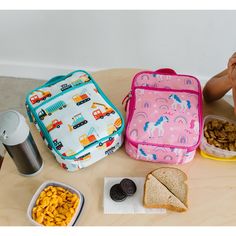 Wildkin's Day2Day kids lunch box features vibrant and playful designs. The double-zipper closure provides little hands with easy access to their favorite items, while the durable top handle is perfect for hanging in a cubby. Your child will love picking out a character that allows them to be more boldly themselves each day. Coordinating nap mat and backpack available in the Day2Day Collection. Playful Multicolor Lunch Box For Playtime, Playful Multicolor Lunch Box For Daycare, Multicolor Rectangular Lunch Box, Cute Multicolor Lunch Box For Everyday Use, Multicolor Rectangular Lunch Box For Playtime, Playful Back To School Lunch Box, Playful Multicolor Lunch Bag, Playful Multicolor Rectangular Lunch Bag, Playful Multicolor Lunch Bag For Playtime