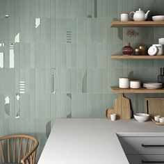 a kitchen with white counter tops and shelves filled with dishes on top of wooden shelves