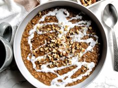 a bowl filled with oatmeal and nuts on top of a white table