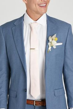 a man in a blue suit with a white flower on his lapel