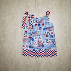 a baby's blue and red outfit hanging on a wall with the words usa printed on it