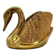 a golden swan figurine sitting on top of a white surface