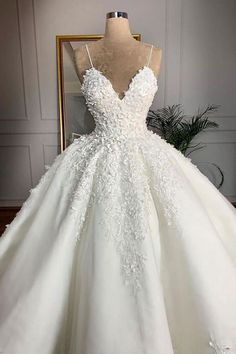 a white wedding dress on display in front of a mannequin