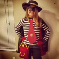 a woman dressed up as a mcdonald's character wearing a hat, tie and glasses