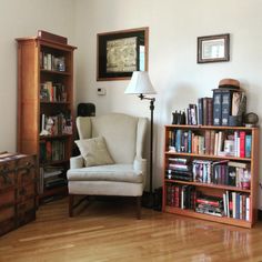 a living room filled with furniture and bookshelves next to a wooden floor covered in hard wood